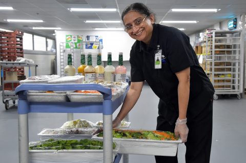 A UChicago Medicine AdventHealth La Grange Food Service team member stocks the salad bar with fresh, healthy ingredients as part of the hospitals' new initiative to offer more food choices that promote healthier dining. [Bruce Powell, Bruce Powell Photography]